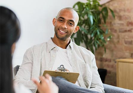 An image of a man in an office holding a clipboard