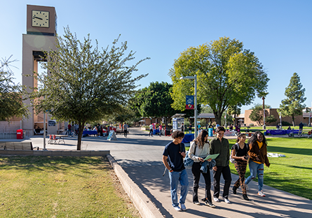 Five MCC students walking across the campus.