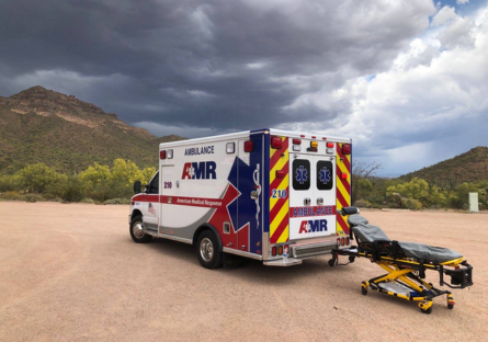 An image of an AMR ambulance and a stretcher in a desert setting 