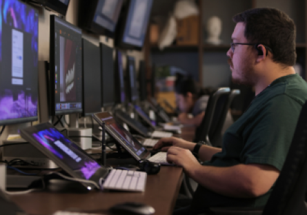 A Maricopa Community Colleges information technology student using multiple computer screens.