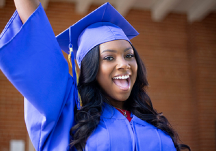 Image of a smiling graduate wearing a cap and gown