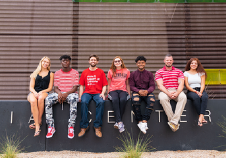 Image of a group of college students sitting on a wall